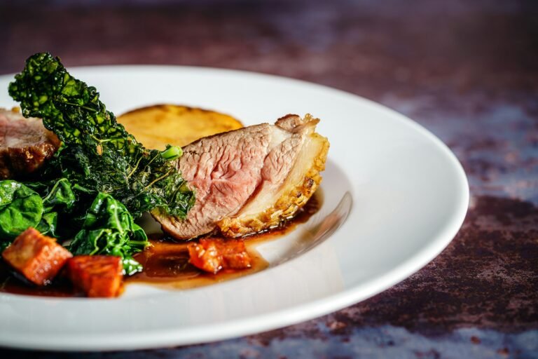 Roast meat with vegetables on a white plate