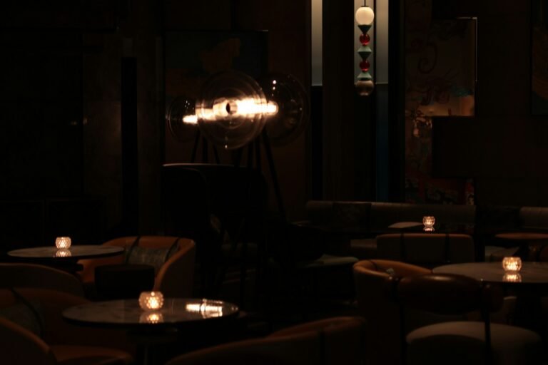 A dim bar room with tables and glowing candles
